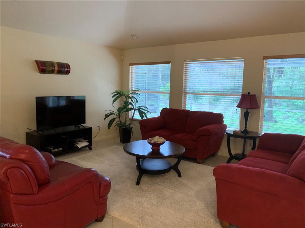 7057 Timberland Circle Naples, FL 34109 - Photo 5 of 22 a living room with furniture a flat screen tv and a window