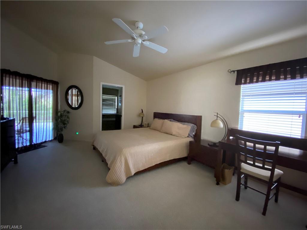 7057 Timberland Circle Naples, FL 34109 - Photo 6 of 22 a spacious bedroom with a bed and dresser with mirror