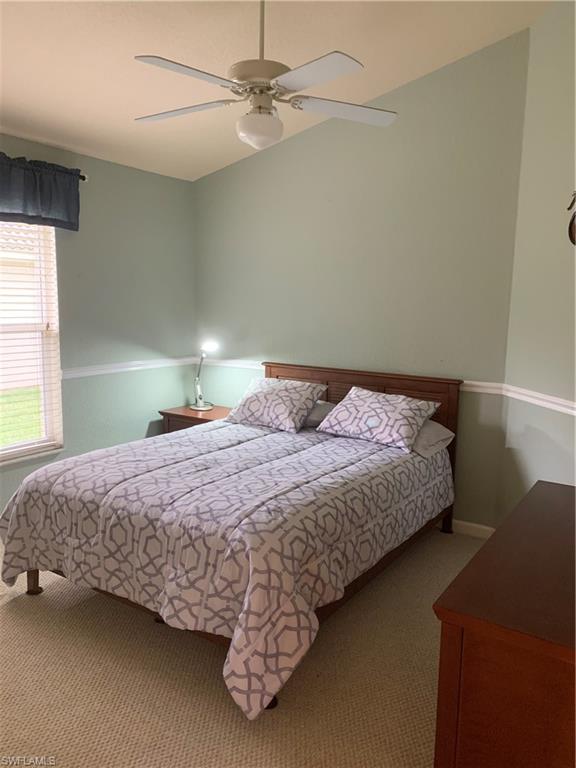 7057 Timberland Circle Naples, FL 34109 - Photo 9 of 22 a bedroom with a bed and a chandelier