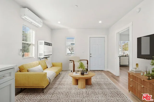 a living room with furniture a flat screen tv and a large window