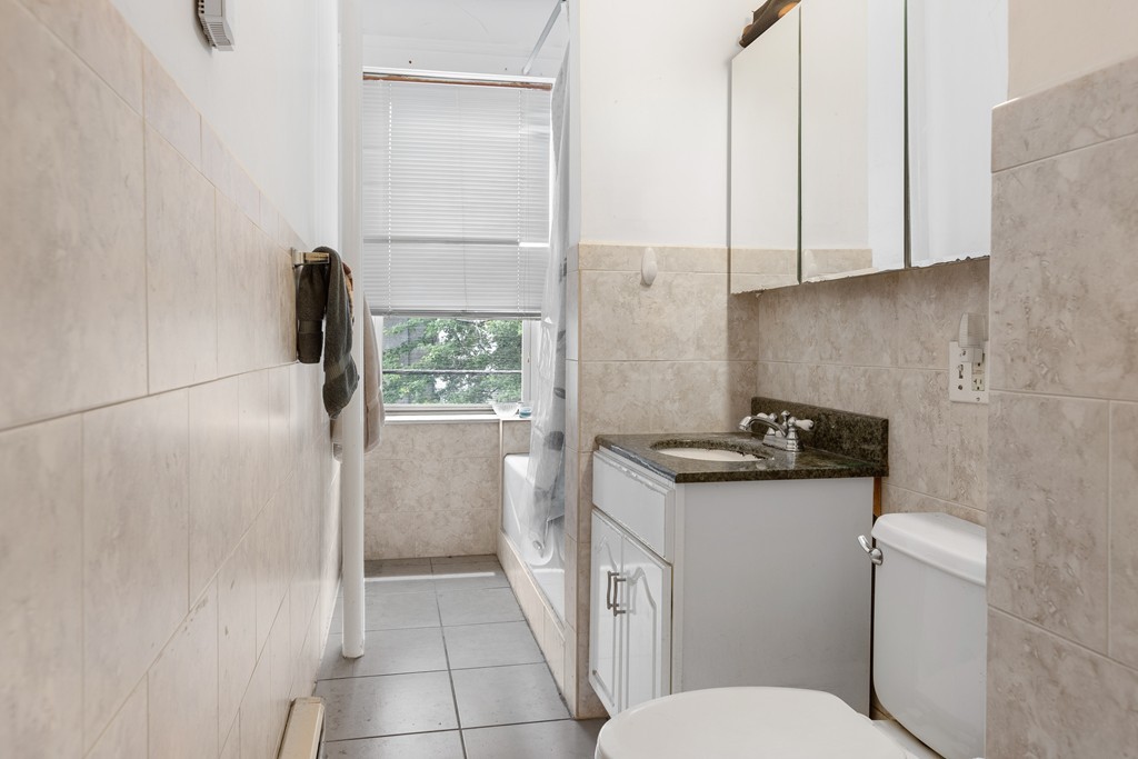 316 Summit Avenue, Unit 6 Boston, MA 02135 - Photo 7 of 9 a bathroom with a granite countertop sink a toilet and a shower