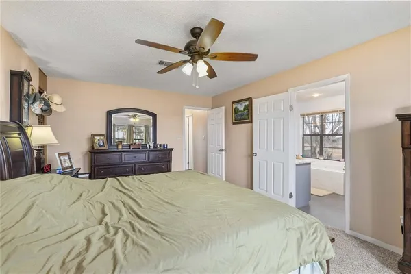 a bedroom with a large bed and a chandelier