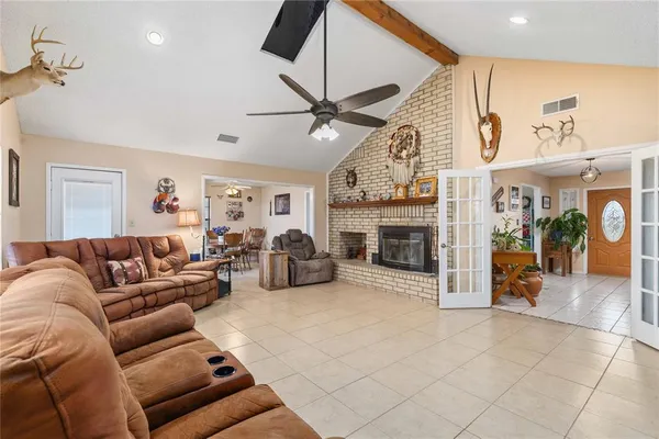 a living room with furniture a fireplace and a ceiling fan