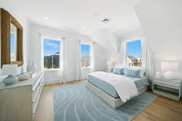 a bedroom with a large bed and windows