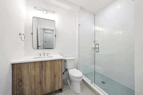 a bathroom with a toilet a sink a vanity and mirror
