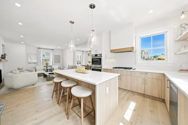 a large kitchen with kitchen island a sink table and chairs