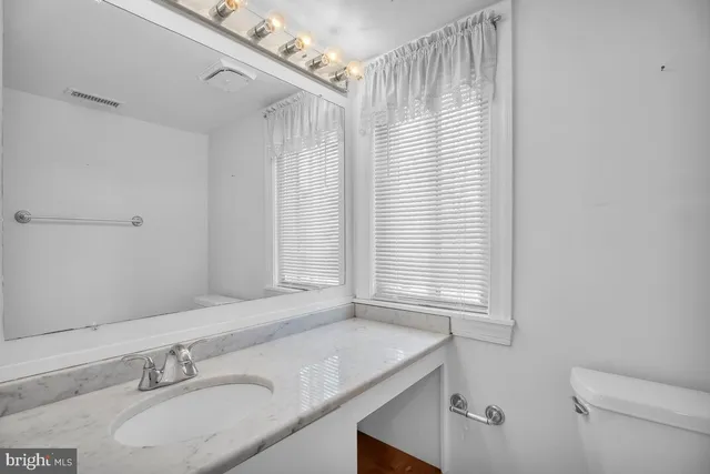 a bathroom with a granite countertop sink and a mirror