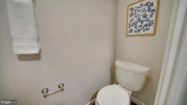 a white toilet sitting next to a white wall