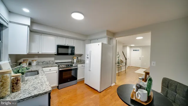 a kitchen with stainless steel appliances granite countertop a sink a stove and a refrigerator