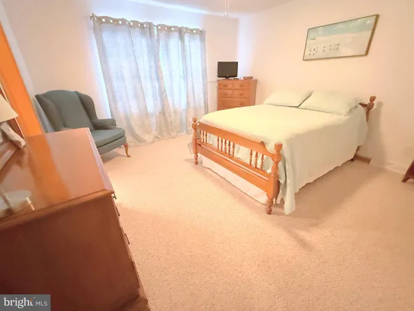 a bed sitting in a spacious bedroom next to a window