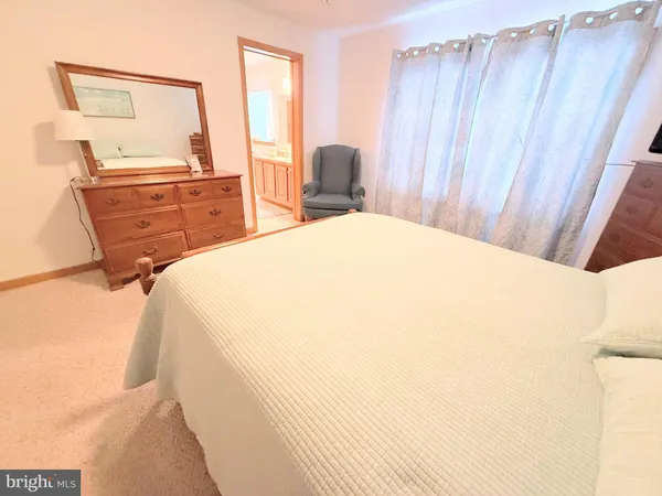a bedroom with a bed and dresser with mirror