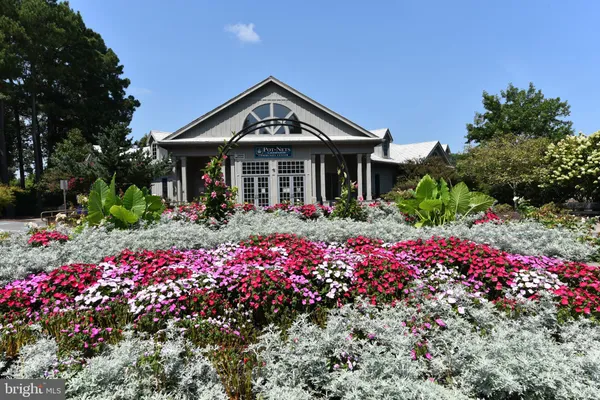 a front view of a house with a flower garden in a yard