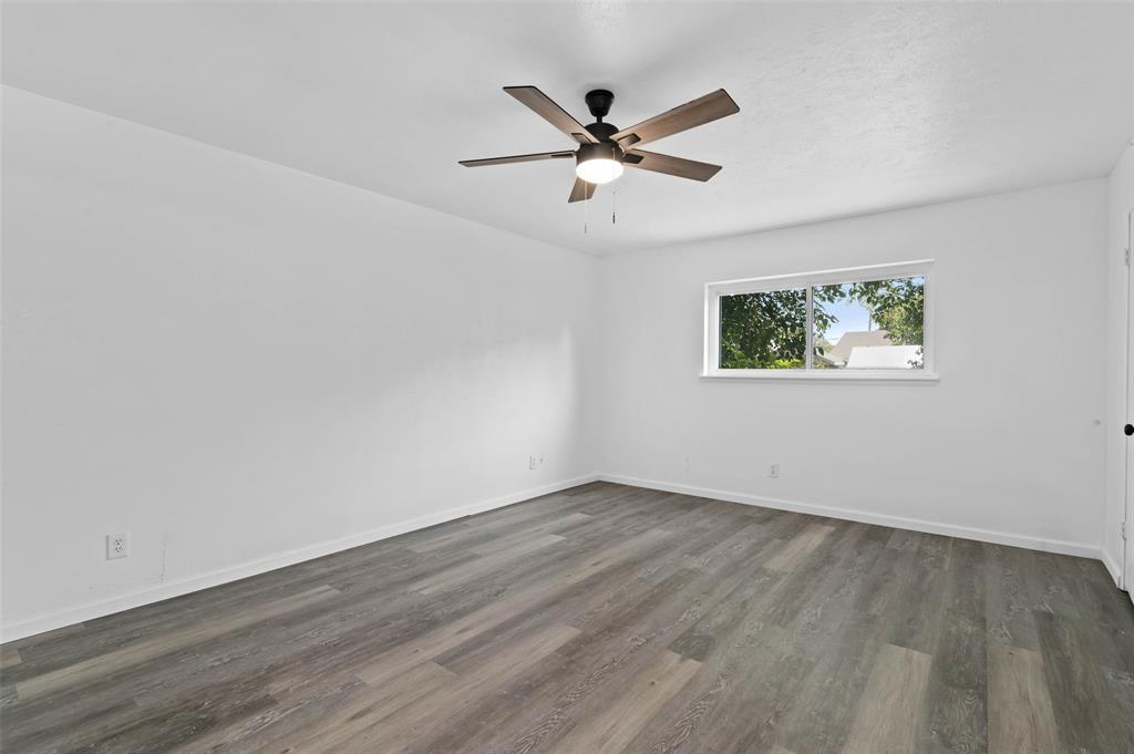 2068 East Peters Colony Road Carrollton, TX 75007 - Photo 12 of 24 a view of an empty room with wooden floor and a window