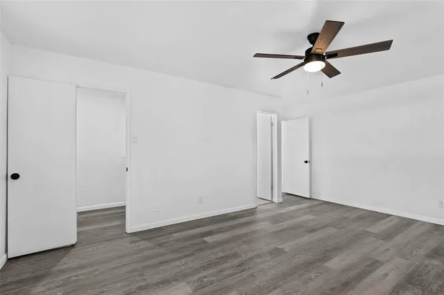 a view of a room with wooden floor and ceiling fan