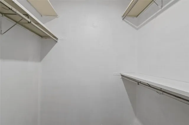 an empty room with a window and wooden floor