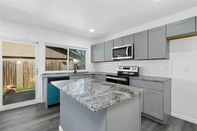 a kitchen with granite countertop a stove and a sink