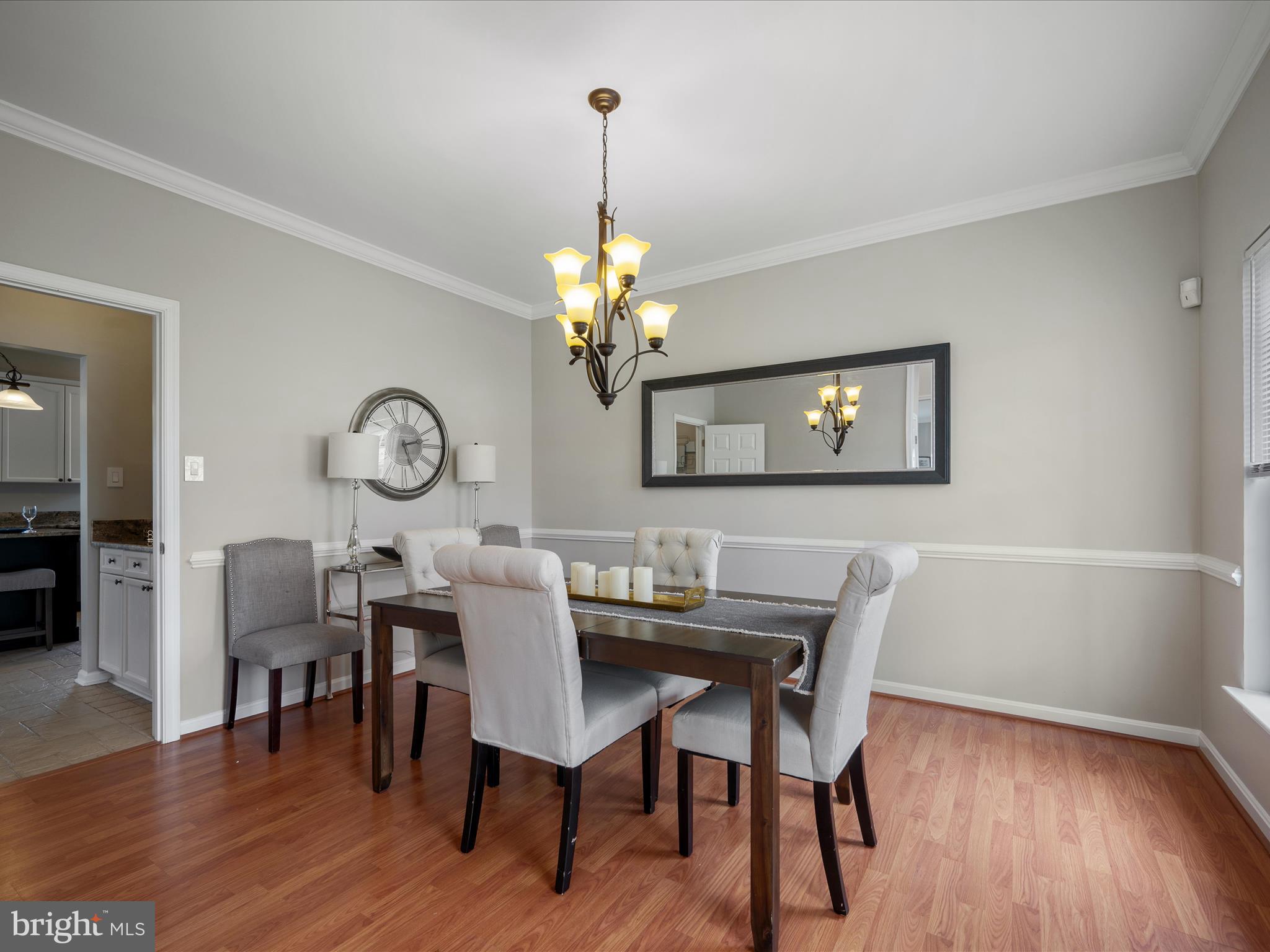 26 Limestone Way Fredericksburg, VA 22406 - Photo 11 of 67 a dining room with wooden floor a chandelier a wooden table and chairs