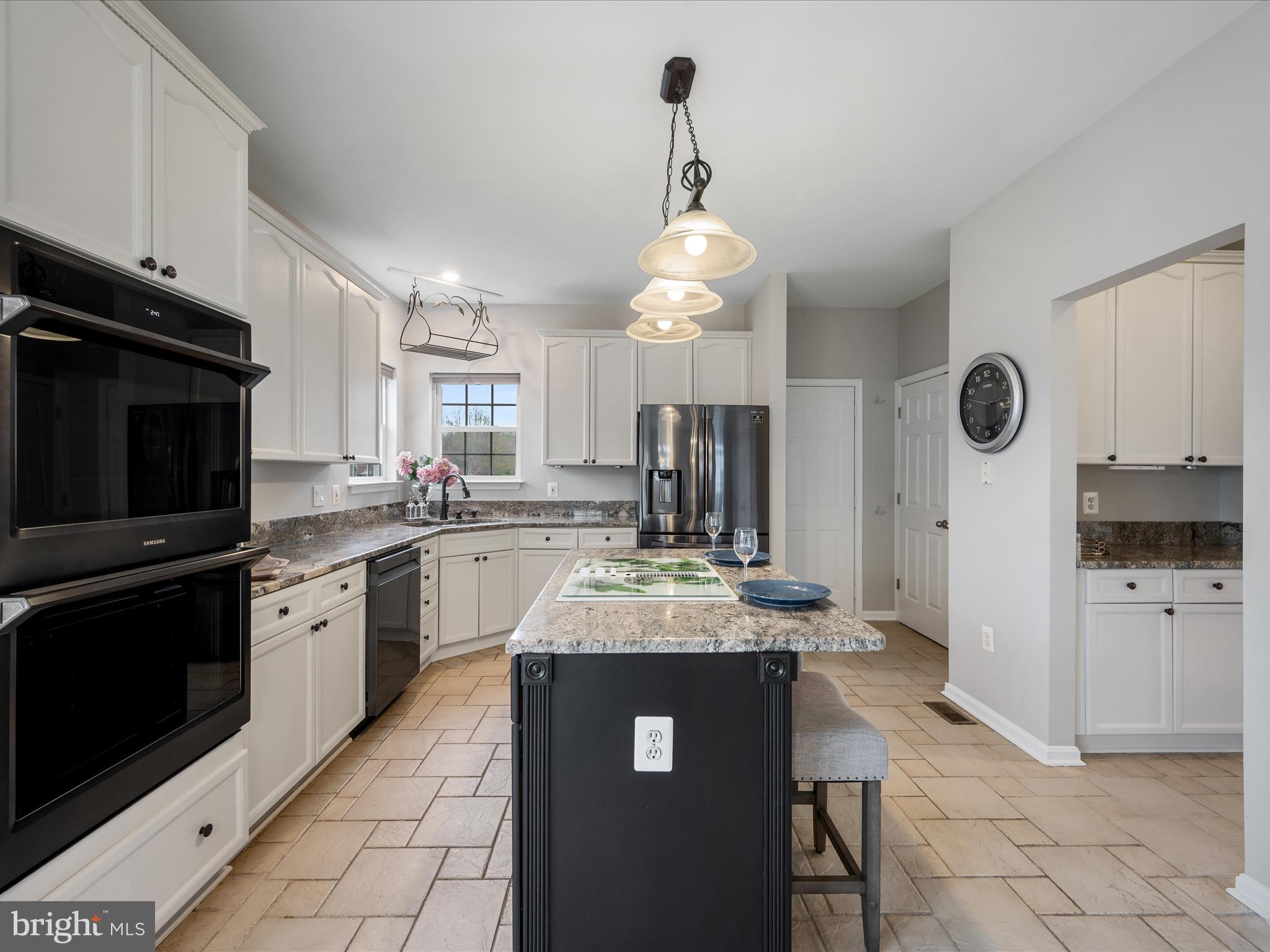 26 Limestone Way Fredericksburg, VA 22406 - Photo 20 of 67 a kitchen with kitchen island granite countertop stainless steel appliances a sink cabinets a counter top space and a center island