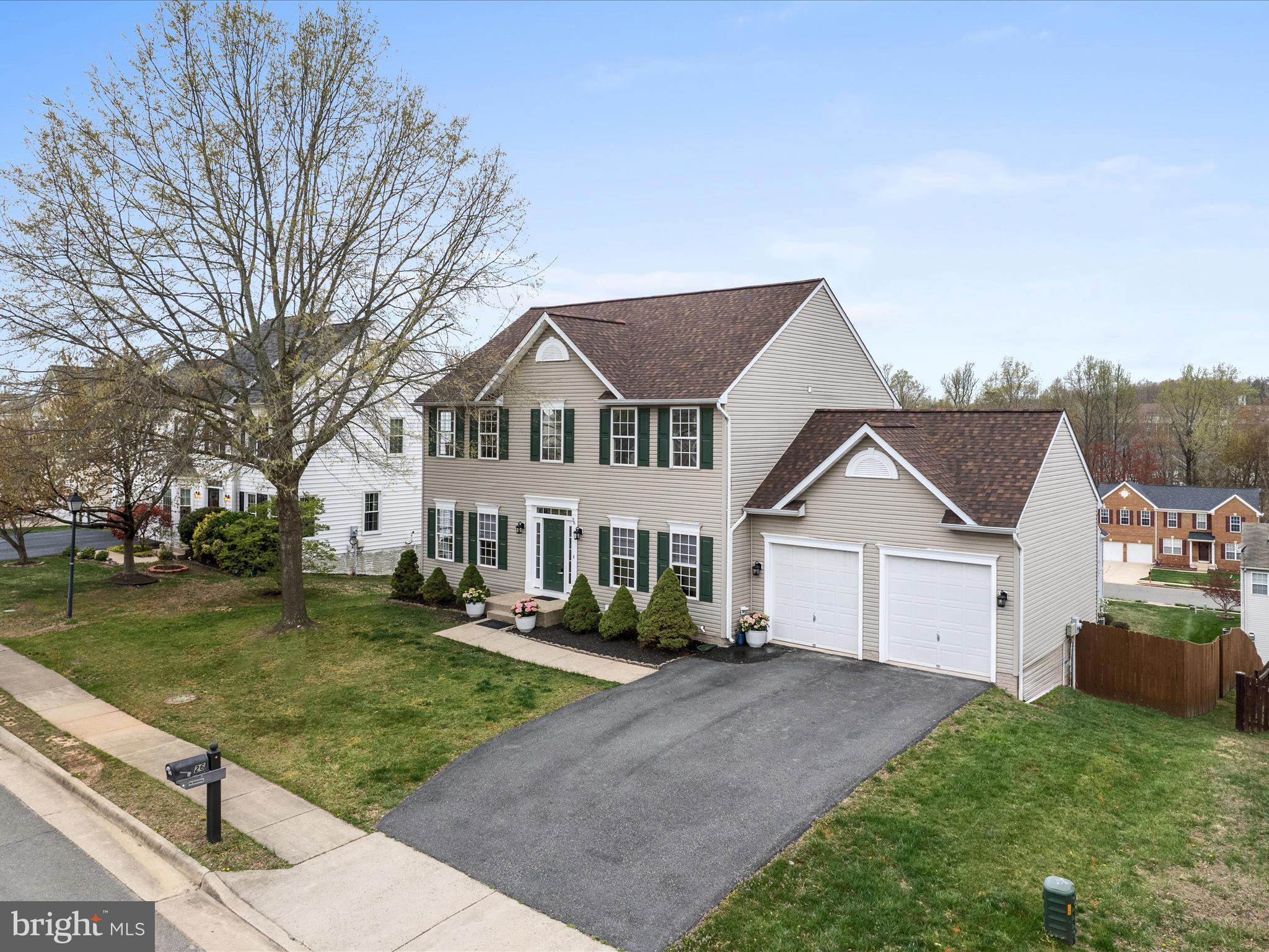 26 Limestone Way Fredericksburg, VA 22406 - Photo 54 of 67 a view of a white house next to a yard with plants and large trees