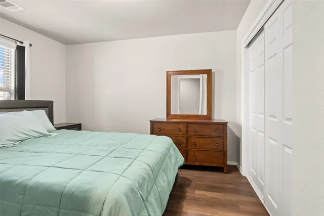 a bedroom with a bed and dresser with mirror