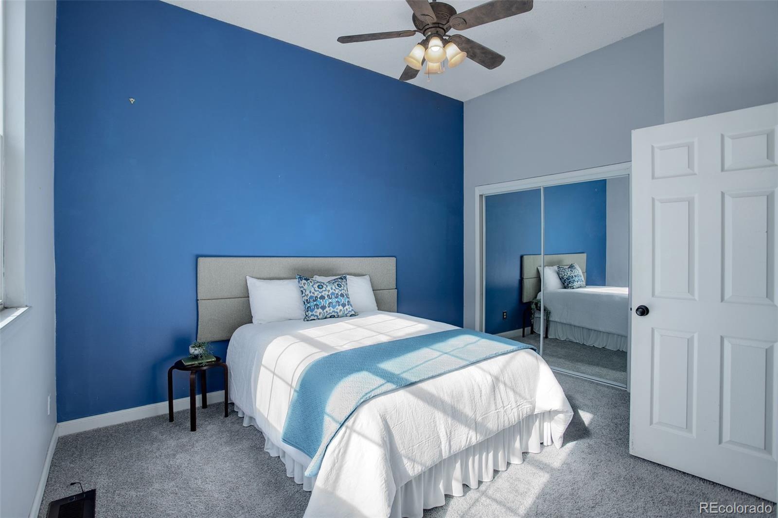 12132 Bannock Circle, Unit E Westminster, CO 80234 - Photo 11 of 26 a bedroom with a bed and a chandelier