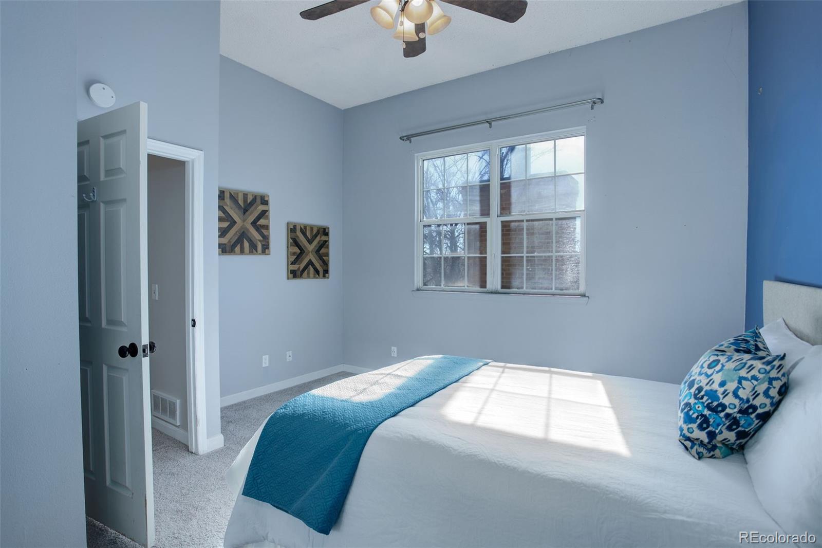 12132 Bannock Circle, Unit E Westminster, CO 80234 - Photo 12 of 26 a bedroom with a bed and a chandelier