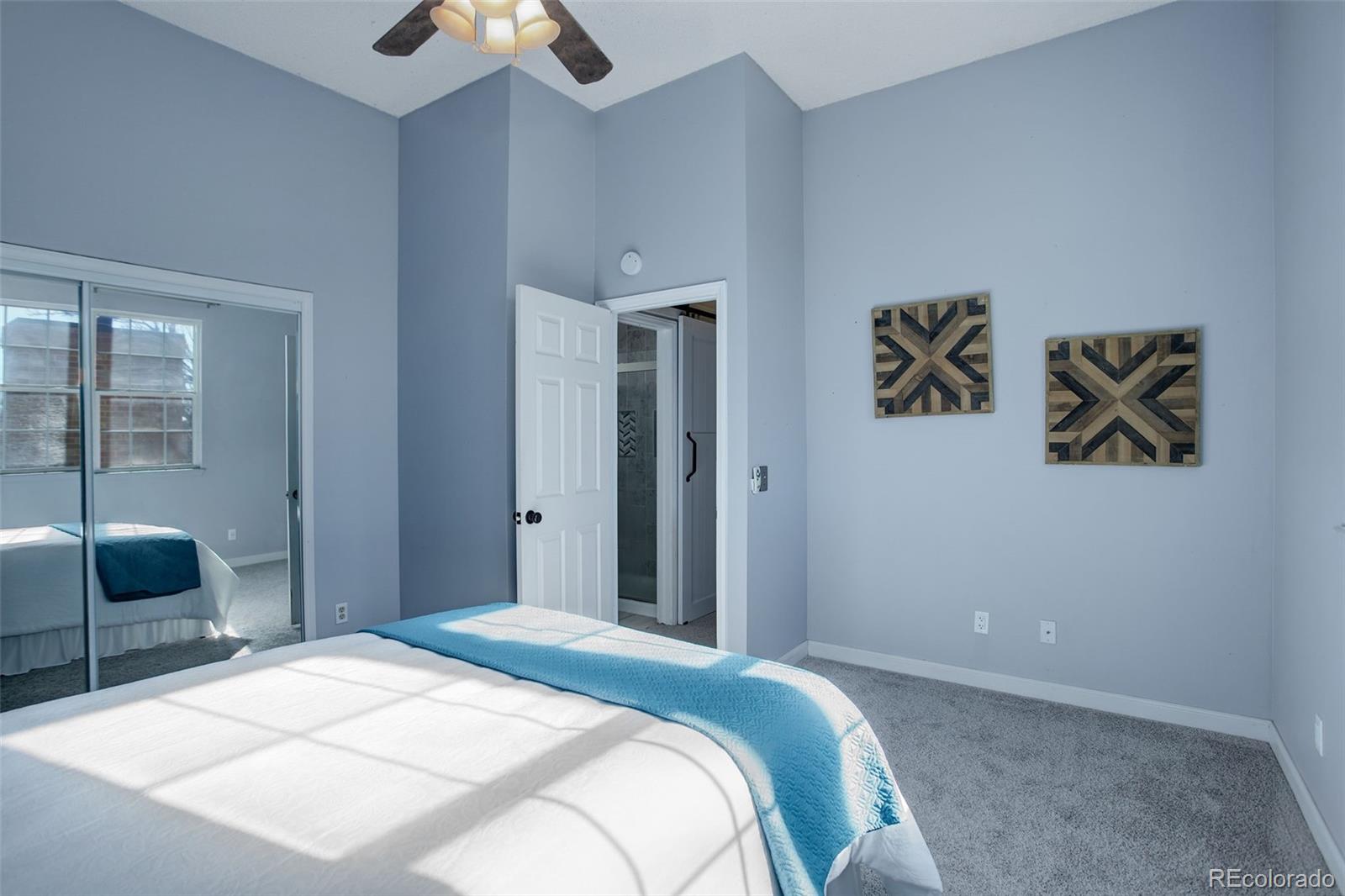 12132 Bannock Circle, Unit E Westminster, CO 80234 - Photo 13 of 26 a bedroom with a bed and a chandelier