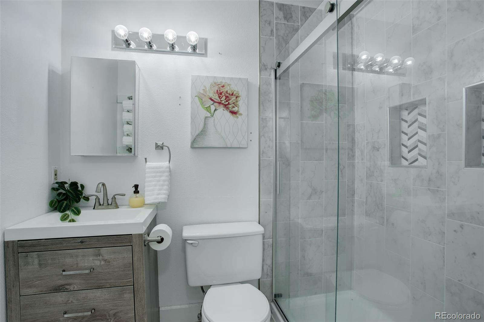 12132 Bannock Circle, Unit E Westminster, CO 80234 - Photo 14 of 26 a bathroom with a sink vanity mirror and toilet