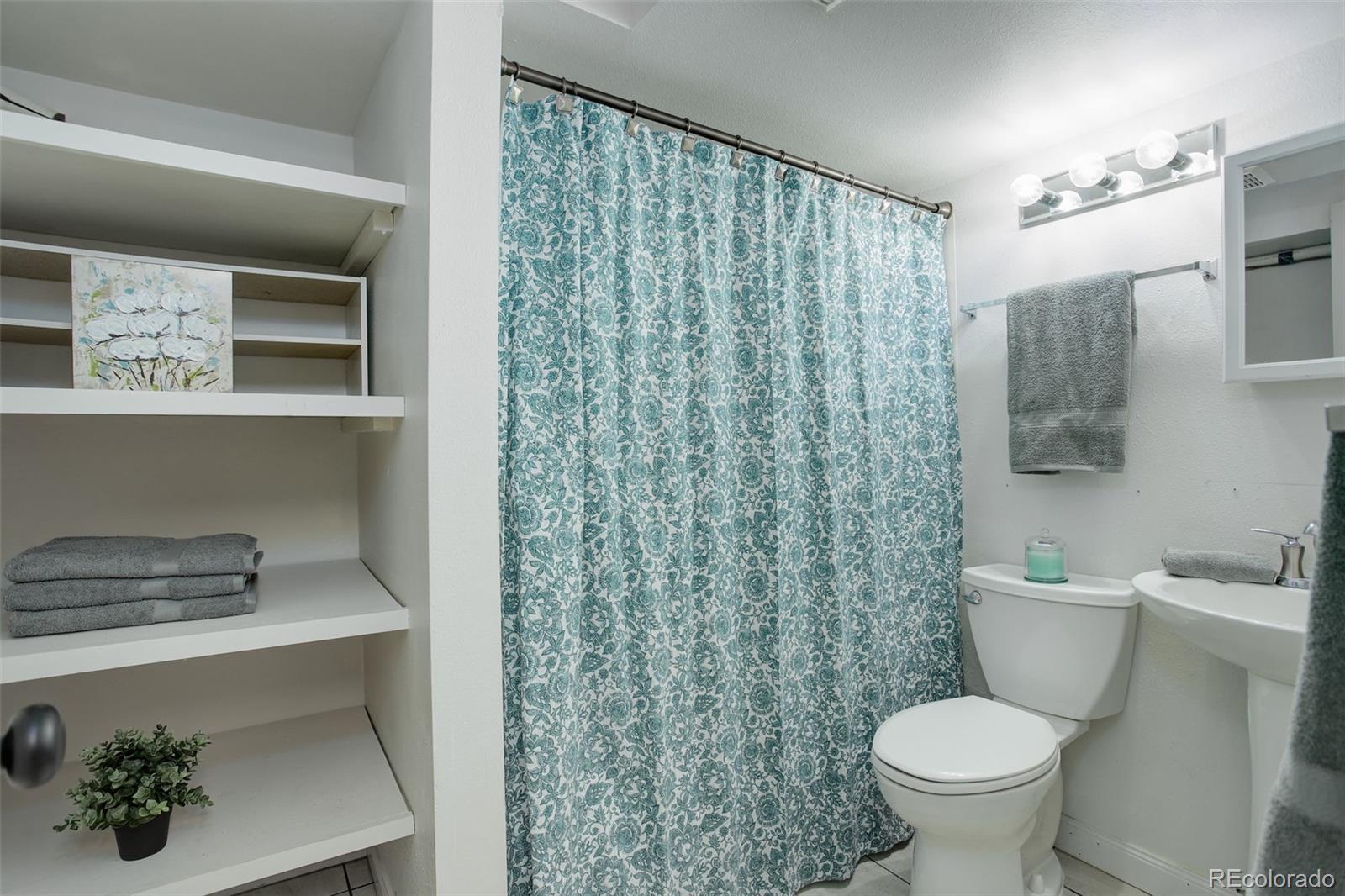 12132 Bannock Circle, Unit E Westminster, CO 80234 - Photo 18 of 26 a bathroom with a toilet sink and shower