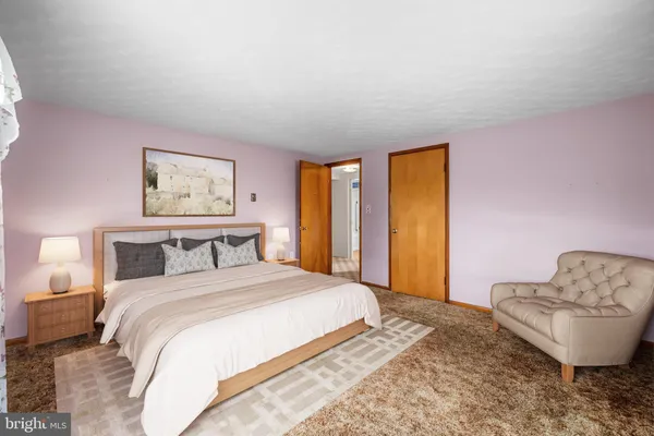 a bedroom with a bed and a painting on the wall