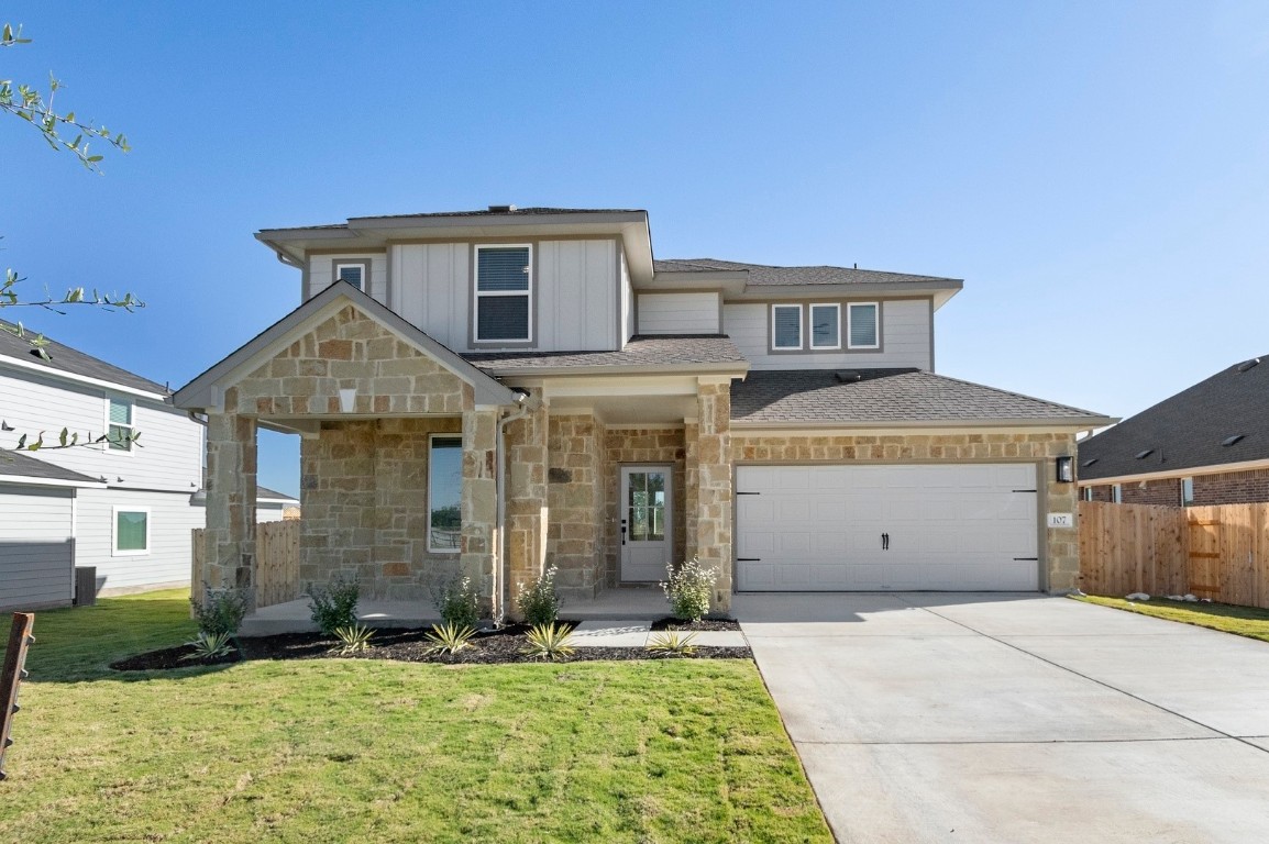View of front of home with a porch, stone siding, driveway, a garage, and a shingled roof