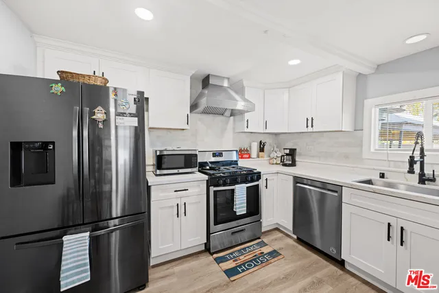 a kitchen with stainless steel appliances granite countertop a stove a refrigerator and a sink