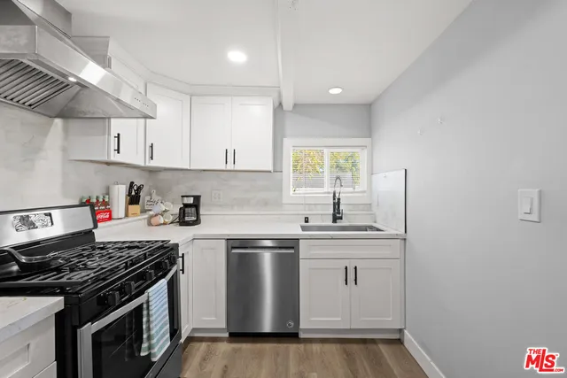 a kitchen with stainless steel appliances a sink stove and cabinets