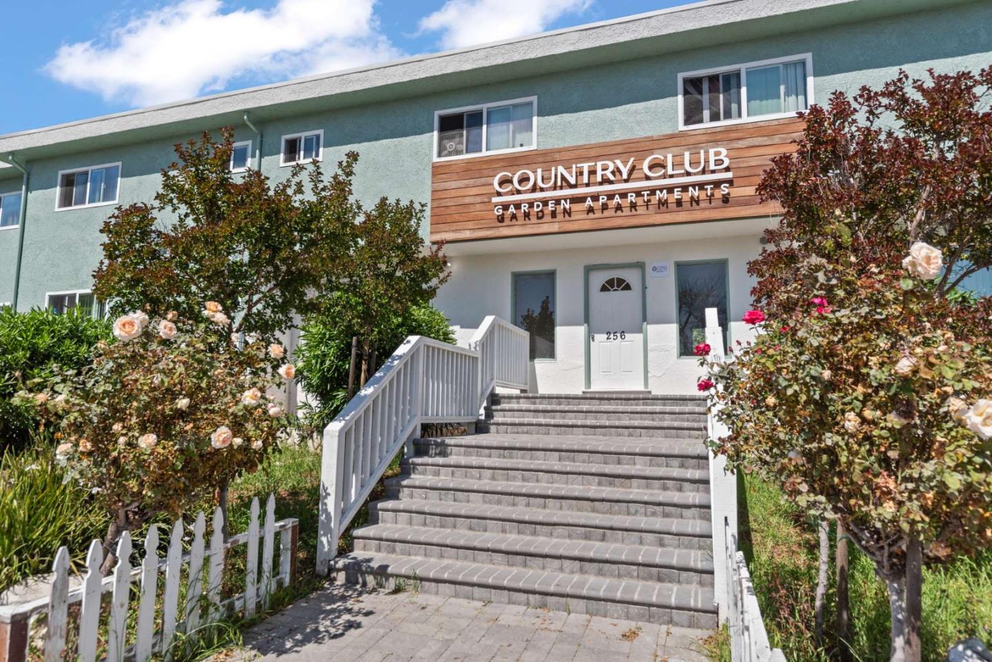 a view of a house with large windows and a small yard