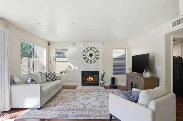 a living room with furniture a flat screen tv and a fireplace