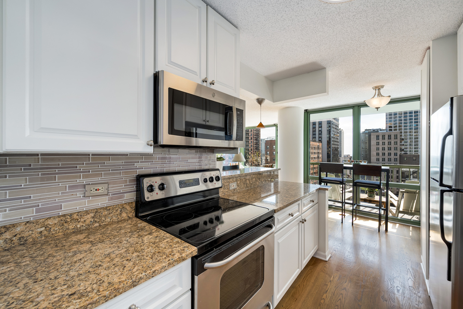 111 West Maple Street, Unit 1601 Chicago, IL 60610 - Photo 13 of 24 a kitchen with a stove a sink and a microwave