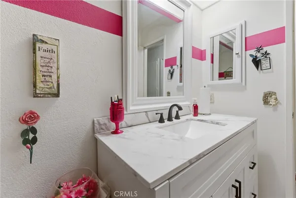 a bathroom with a sink vanity and mirror