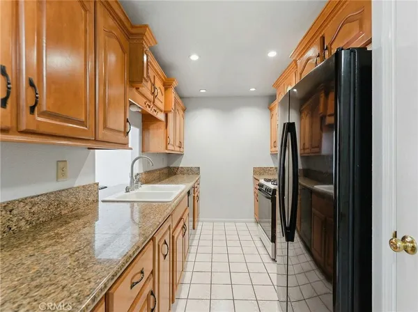 a kitchen with a sink a refrigerator and cabinets