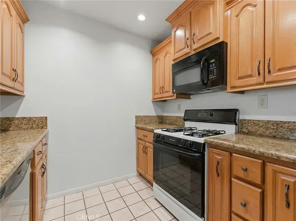 a kitchen with stainless steel appliances granite countertop a stove top oven microwave and cabinets