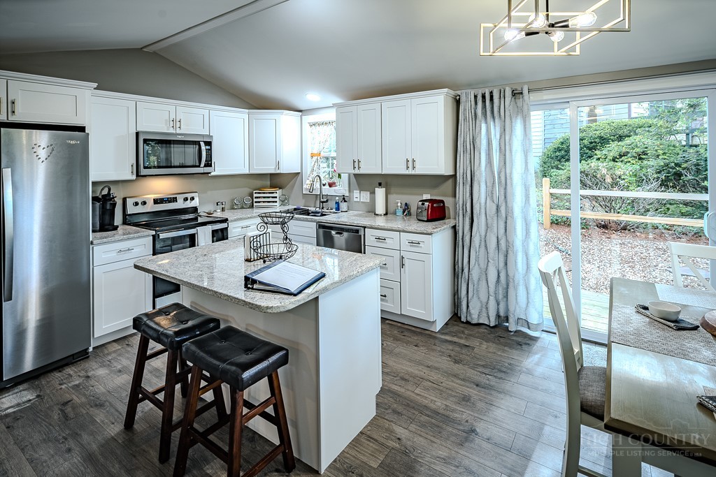 88 Trillium Road Newland, NC 28657 - Photo 19 of 44 a kitchen with stainless steel appliances a stove a sink a refrigerator white cabinets and wooden floor