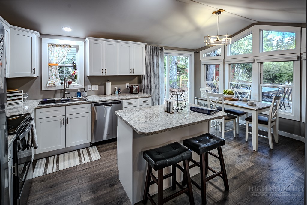 88 Trillium Road Newland, NC 28657 - Photo 21 of 44 a kitchen with a table chairs stove and cabinets