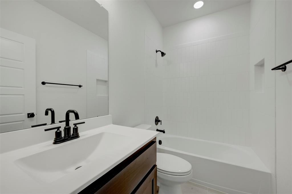 1908 Cola Drive Van Alstyne, TX 75495 - Photo 29 of 29 Bathroom vanity featuring a single basin, dark wood-finish cabinetry, and matte black fixtures