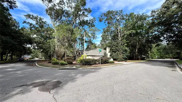 a view of a street with a house and trees in the background