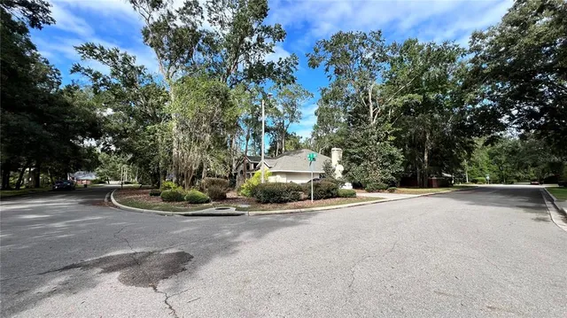 a view of a street with a house and trees in the background
