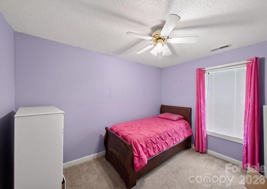 2205 Old Sparta Road Rocky Mount, NC 27804 - Photo 22 of 25 a bedroom with a bed and a chandelier