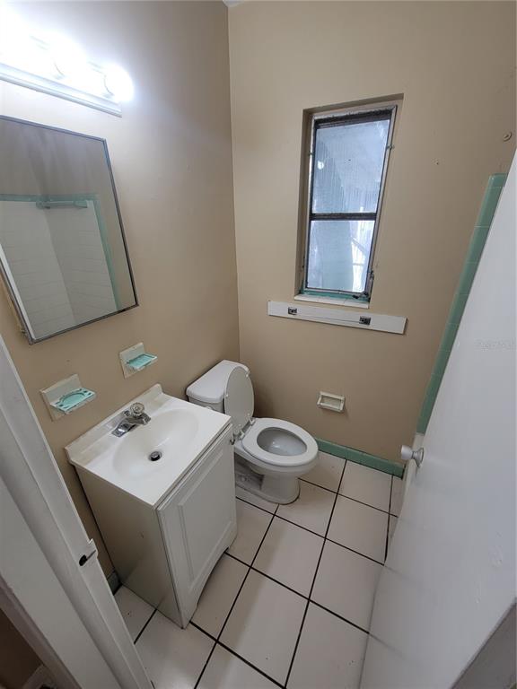 698 Union Street, Unit 4 Dunedin, FL 34698 - Photo 5 of 5 a bathroom with a toilet sink and mirror