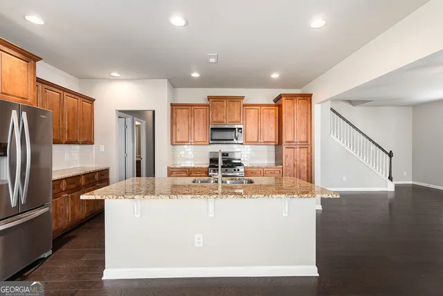 a view of a kitchen with kitchen island a counter top space stainless steel appliances and cabinets