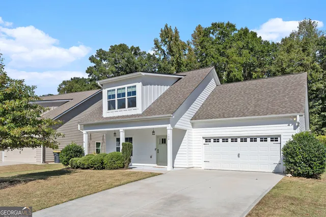 a front view of a house with a yard and trees