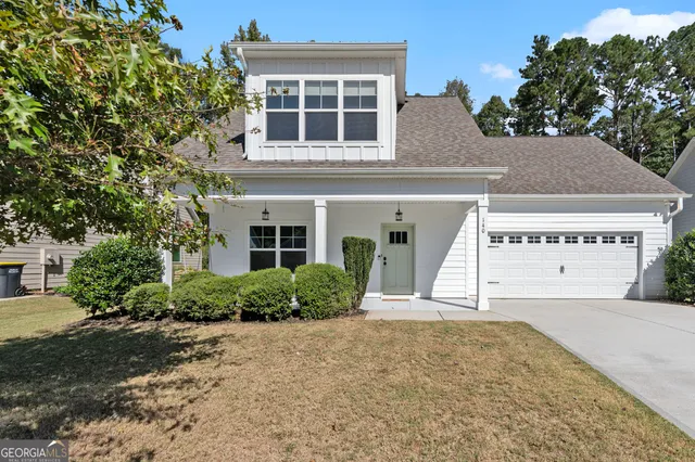 a view of a house with a yard and potted plants