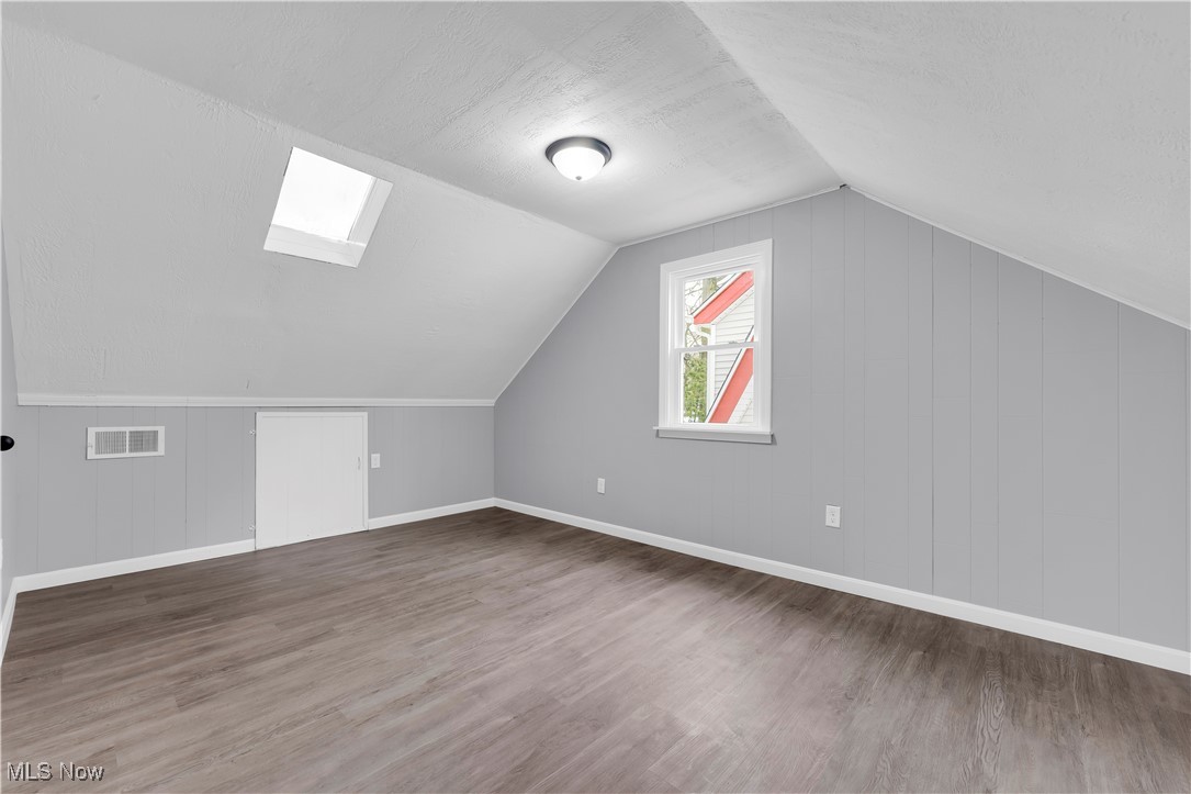 953 Whitby Road Cleveland Heights, OH 44112 - Photo 18 of 27 Additional living space featuring a skylight, wooden walls, and light wood finished floors